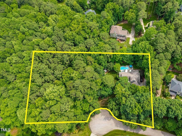 7401 Heartland Dr, Wake Forest, NC 27587 - aerial view of property and surrounding area featuring a heavily wooded area and property parcel outlined