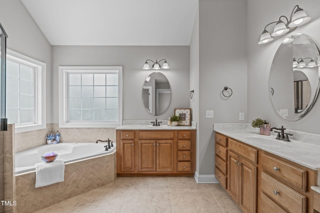 297 Curragh Cv, Fuquay Varina, NC 27526 - full bath featuring two vanities, a garden tub, lofted ceiling, and tile patterned floors