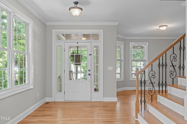 297 Curragh Cv, Fuquay Varina, NC 27526 - foyer with light wood-style flooring, stairs, baseboards, and crown molding