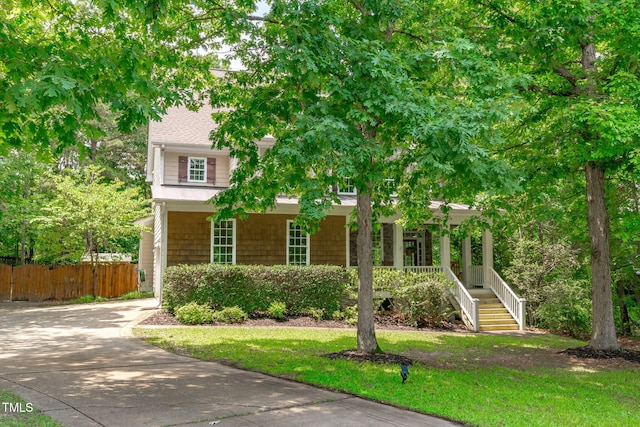 297 Curragh Cv, Fuquay Varina, NC 27526 - view of property hidden behind natural elements featuring covered porch, driveway, stairs, and roof with shingles