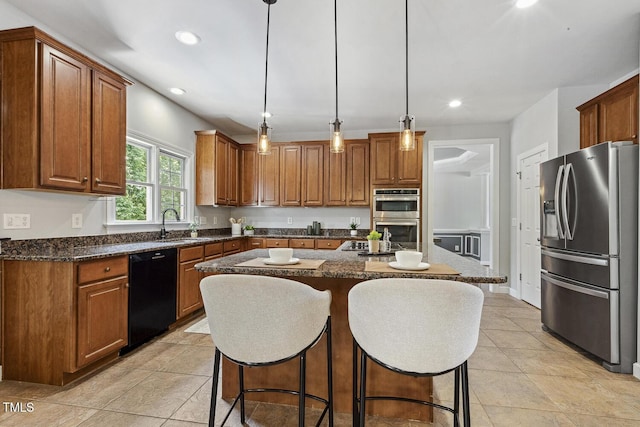 825 Highwater Pl, Fuquay Varina, NC 27526 - kitchen featuring stainless steel appliances, a breakfast bar, a center island, brown cabinets, and recessed lighting