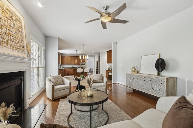 825 Highwater Pl, Fuquay Varina, NC 27526 - living area with wood finished floors, a ceiling fan, a fireplace with raised hearth, recessed lighting, and a chandelier