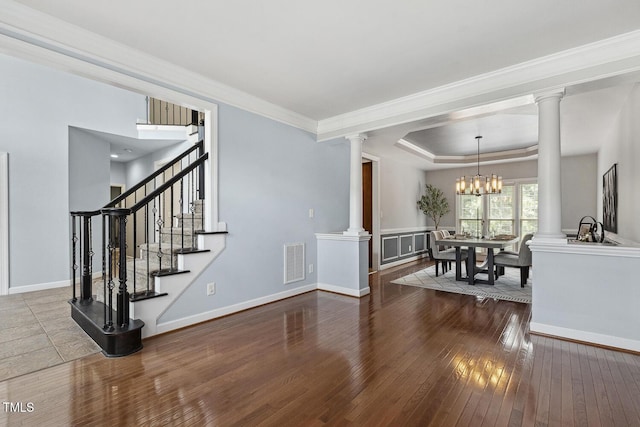 825 Highwater Pl, Fuquay Varina, NC 27526 - living room with ornate columns, hardwood / wood-style flooring, a tray ceiling, a chandelier, and crown molding