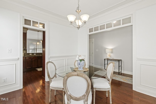 853 Bluffcreek Dr, Fuquay Varina, NC 27526 - dining room with dark wood-style flooring, a chandelier, ornamental molding, a decorative wall, and wainscoting