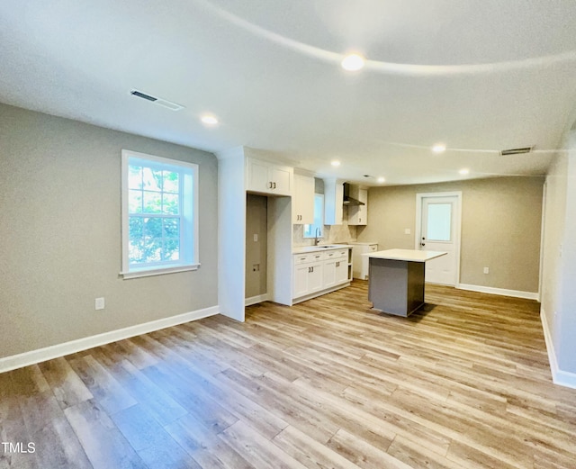 505 E Canary St, Dunn, NC 28334 - kitchen featuring a sink, a center island, white cabinetry, baseboards, and light wood-type flooring