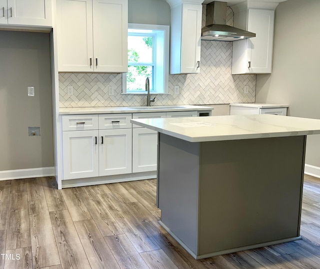505 E Canary St, Dunn, NC 28334 - kitchen with wall chimney exhaust hood, a sink, light wood-style floors, and tasteful backsplash