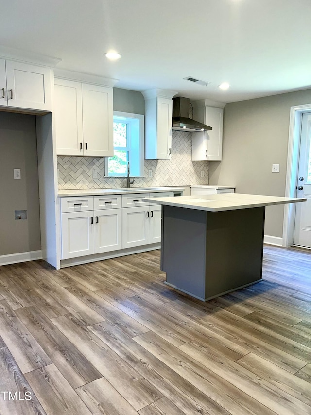 505 E Canary St, Dunn, NC 28334 - kitchen featuring wall chimney exhaust hood, white cabinets, backsplash, light countertops, and recessed lighting