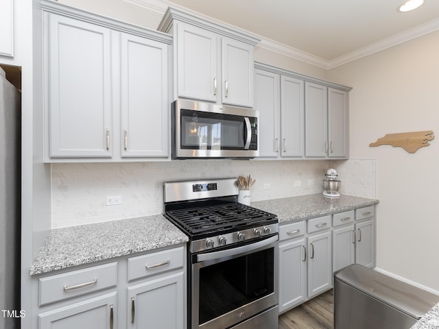 601 Grand Central Sta, Apex, NC 27502 - kitchen featuring appliances with stainless steel finishes, ornamental molding, tasteful backsplash, light stone countertops, and light wood finished floors