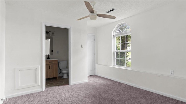 2396 Spring Valley Rd, Henderson, NC 27537 - unfurnished bedroom featuring carpet, ensuite bath, a textured ceiling, and baseboards