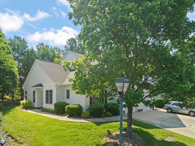 1 Lake Hill Dr, Durham, NC 27713 - view of property hidden behind natural elements with a front lawn and a shingled roof