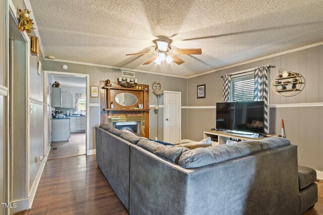 819 Corbin St, Albemarle, NC 28001 - living room featuring a ceiling fan, dark wood-style floors, a textured ceiling, ornamental molding, and a fireplace