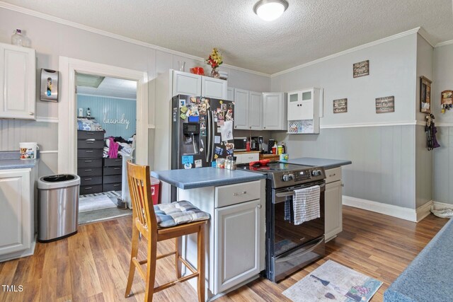 819 Corbin St, Albemarle, NC 28001 - kitchen featuring stainless steel fridge with ice dispenser, range with electric cooktop, light wood-style flooring, a textured ceiling, and crown molding