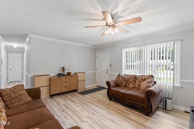 509 Forest Ridge Rd, Garner, NC 27529 - living room featuring a textured ceiling, ornamental molding, light wood-type flooring, and a ceiling fan