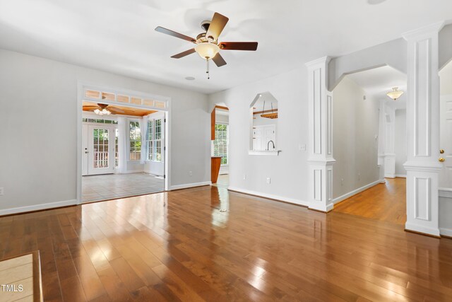 104 Shady Ridge Ct, Apex, NC 27502 - unfurnished living room with ceiling fan, wood-type flooring, arched walkways, and baseboards