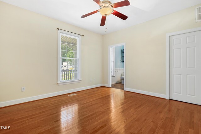 104 Shady Ridge Ct, Apex, NC 27502 - unfurnished bedroom with wood finished floors, baseboards, ensuite bath, and a ceiling fan