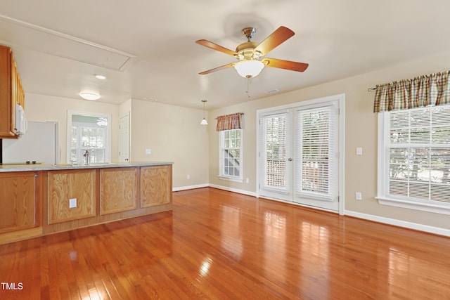 104 Shady Ridge Ct, Apex, NC 27502 - unfurnished living room with attic access, light wood-style floors, baseboards, and plenty of natural light