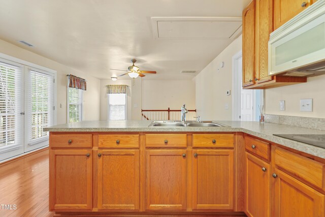 104 Shady Ridge Ct, Apex, NC 27502 - kitchen with white microwave, a sink, a peninsula, light countertops, and light wood-style flooring