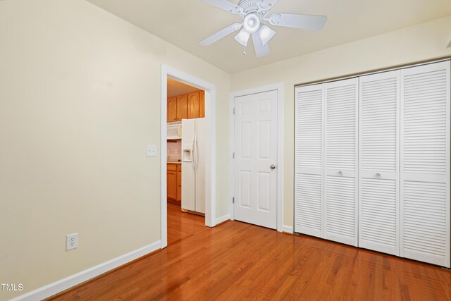 104 Shady Ridge Ct, Apex, NC 27502 - unfurnished bedroom featuring white refrigerator with ice dispenser, light wood-style flooring, baseboards, a closet, and ceiling fan