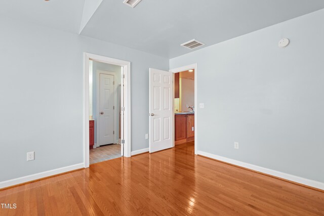 104 Shady Ridge Ct, Apex, NC 27502 - unfurnished bedroom with baseboards, light wood-style flooring, and connected bathroom