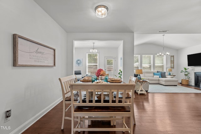 3032 Curling Creek Dr, Apex, NC 27502 - dining area with a chandelier, wood finished floors, plenty of natural light, a fireplace with flush hearth, and vaulted ceiling