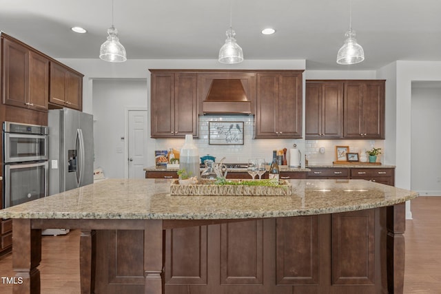 3032 Curling Creek Dr, Apex, NC 27502 - kitchen featuring custom exhaust hood, stainless steel appliances, wood finished floors, decorative backsplash, and recessed lighting
