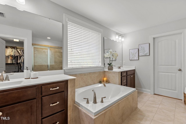 3032 Curling Creek Dr, Apex, NC 27502 - bathroom featuring vanity, a shower stall, tile patterned floors, a garden tub, and a walk in closet