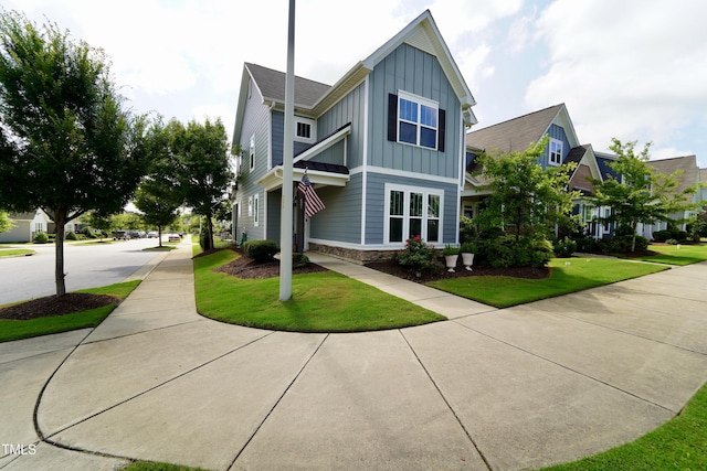421 Old Ride Dr, Holly Springs, NC 27540 - view of front of property with board and batten siding, stone siding, and a front lawn