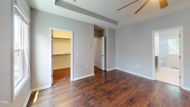 421 Old Ride Dr, Holly Springs, NC 27540 - unfurnished bedroom with wood finished floors, a spacious closet, a closet, baseboards, and a tray ceiling