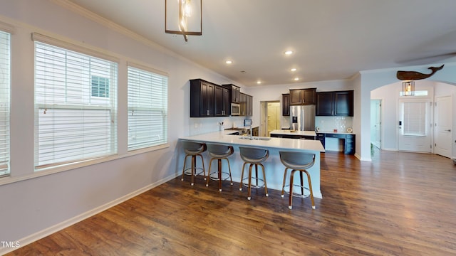 421 Old Ride Dr, Holly Springs, NC 27540 - kitchen with appliances with stainless steel finishes, ornamental molding, a sink, a kitchen breakfast bar, and baseboards