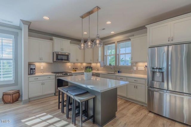 1624 Tunnel St, Wendell, NC 27591 - kitchen featuring stainless steel appliances, a kitchen breakfast bar, light countertops, light wood-style flooring, and a center island