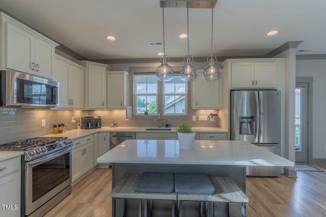 1624 Tunnel St, Wendell, NC 27591 - kitchen featuring appliances with stainless steel finishes, light countertops, tasteful backsplash, recessed lighting, and ornamental molding