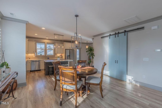 1624 Tunnel St, Wendell, NC 27591 - dining space with a barn door, light wood-style flooring, and recessed lighting