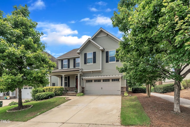 428 Mill Station Ln, Wendell, NC 27591 - view of front of home featuring an attached garage, driveway, a shingled roof, stone siding, and a porch