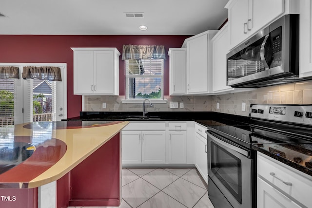 428 Mill Station Ln, Wendell, NC 27591 - kitchen with appliances with stainless steel finishes, plenty of natural light, white cabinetry, backsplash, and recessed lighting