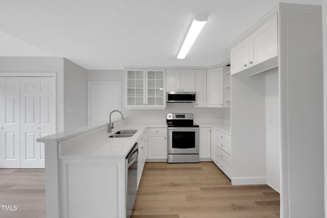 248 Robin Loop, Dunn, NC 28334 - kitchen featuring appliances with stainless steel finishes, a sink, a peninsula, and light wood-style flooring
