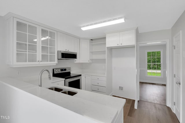 248 Robin Loop, Dunn, NC 28334 - kitchen featuring stainless steel appliances, open shelves, wood finished floors, white cabinetry, and glass insert cabinets