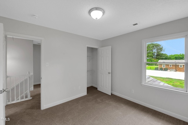 248 Robin Loop, Dunn, NC 28334 - unfurnished bedroom featuring carpet floors, baseboards, a spacious closet, and a closet
