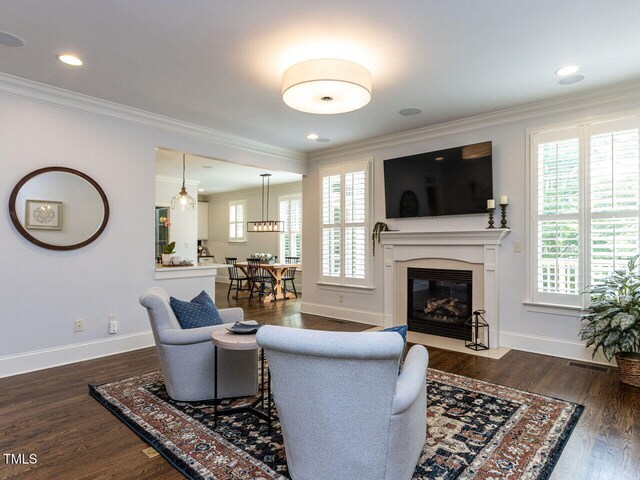 612 Peach Orchard Pl, Cary, NC 27519 - living area with ornamental molding, healthy amount of natural light, baseboards, a high end fireplace, and dark wood finished floors