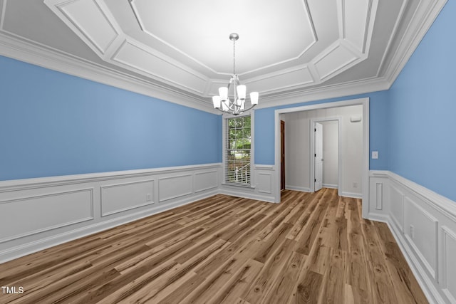 2913 Coxindale Dr, Raleigh, NC 27615 - spare room featuring a chandelier, ornamental molding, a wainscoted wall, wood finished floors, and a decorative wall