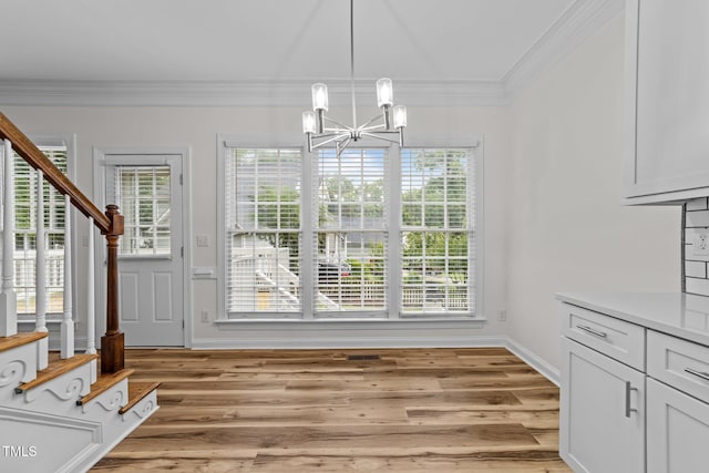 2913 Coxindale Dr, Raleigh, NC 27615 - unfurnished dining area with stairway, a chandelier, ornamental molding, and light wood-type flooring
