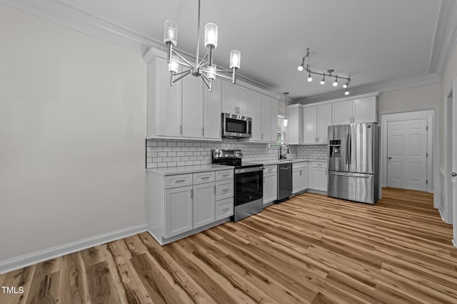 2913 Coxindale Dr, Raleigh, NC 27615 - kitchen with appliances with stainless steel finishes, ornamental molding, light countertops, a chandelier, and light wood finished floors
