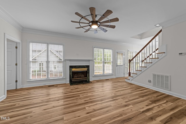 2913 Coxindale Dr, Raleigh, NC 27615 - unfurnished living room featuring ornamental molding, ceiling fan, stairs, light wood-style floors, and a fireplace