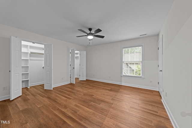 2913 Coxindale Dr, Raleigh, NC 27615 - unfurnished bedroom featuring light wood finished floors, a walk in closet, and a ceiling fan