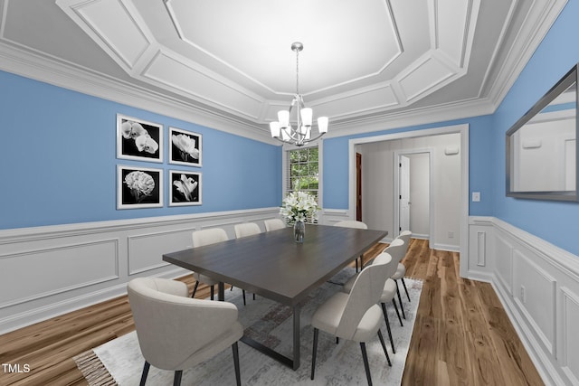 2913 Coxindale Dr, Raleigh, NC 27615 - dining space featuring a chandelier, light wood finished floors, a decorative wall, wainscoting, and crown molding