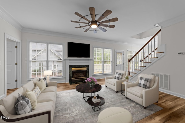2913 Coxindale Dr, Raleigh, NC 27615 - living area with a ceiling fan, crown molding, wood finished floors, a premium fireplace, and stairs