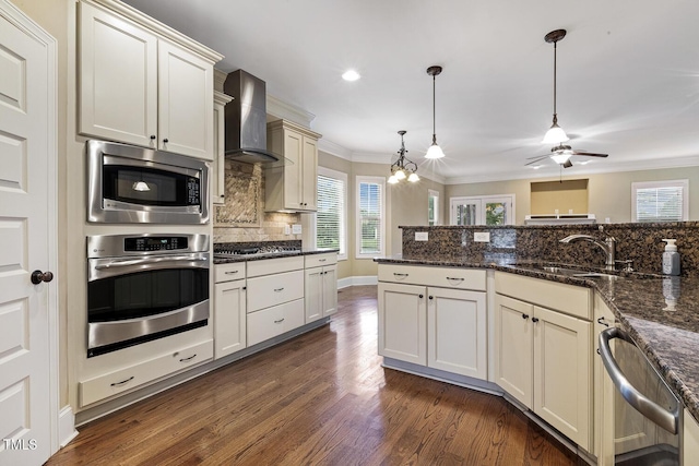 513 Goal Kick, Fuquay Varina, NC 27526 - kitchen with stainless steel appliances, plenty of natural light, decorative backsplash, wall chimney exhaust hood, and ornamental molding