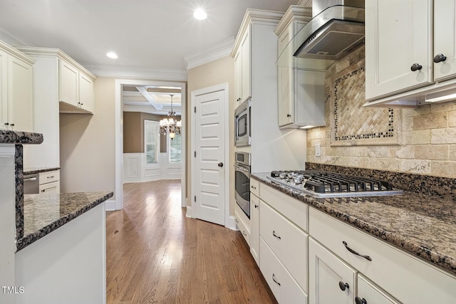 513 Goal Kick, Fuquay Varina, NC 27526 - kitchen with stainless steel appliances, wall chimney range hood, crown molding, a chandelier, and dark stone counters