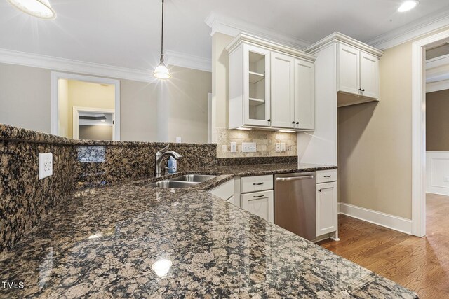 513 Goal Kick, Fuquay Varina, NC 27526 - kitchen with stainless steel dishwasher, dark stone counters, light wood-style floors, ornamental molding, and backsplash