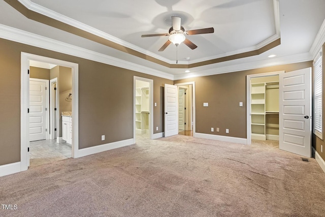 513 Goal Kick, Fuquay Varina, NC 27526 - unfurnished bedroom with a walk in closet, light carpet, a raised ceiling, crown molding, and connected bathroom