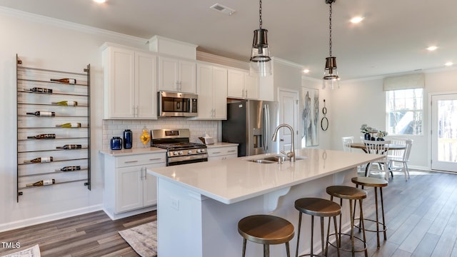 219 Carova Bnd, Apex, NC 27539 - kitchen with stainless steel appliances, a sink, dark wood finished floors, crown molding, and an island with sink